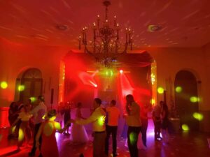 Volle Tanzfläche unter dem Kronleuchter bei einer Hochzeit